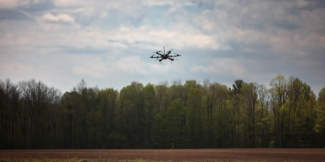 Hexacoptère en vol au-dessus d'un champ lors d'essais terrain